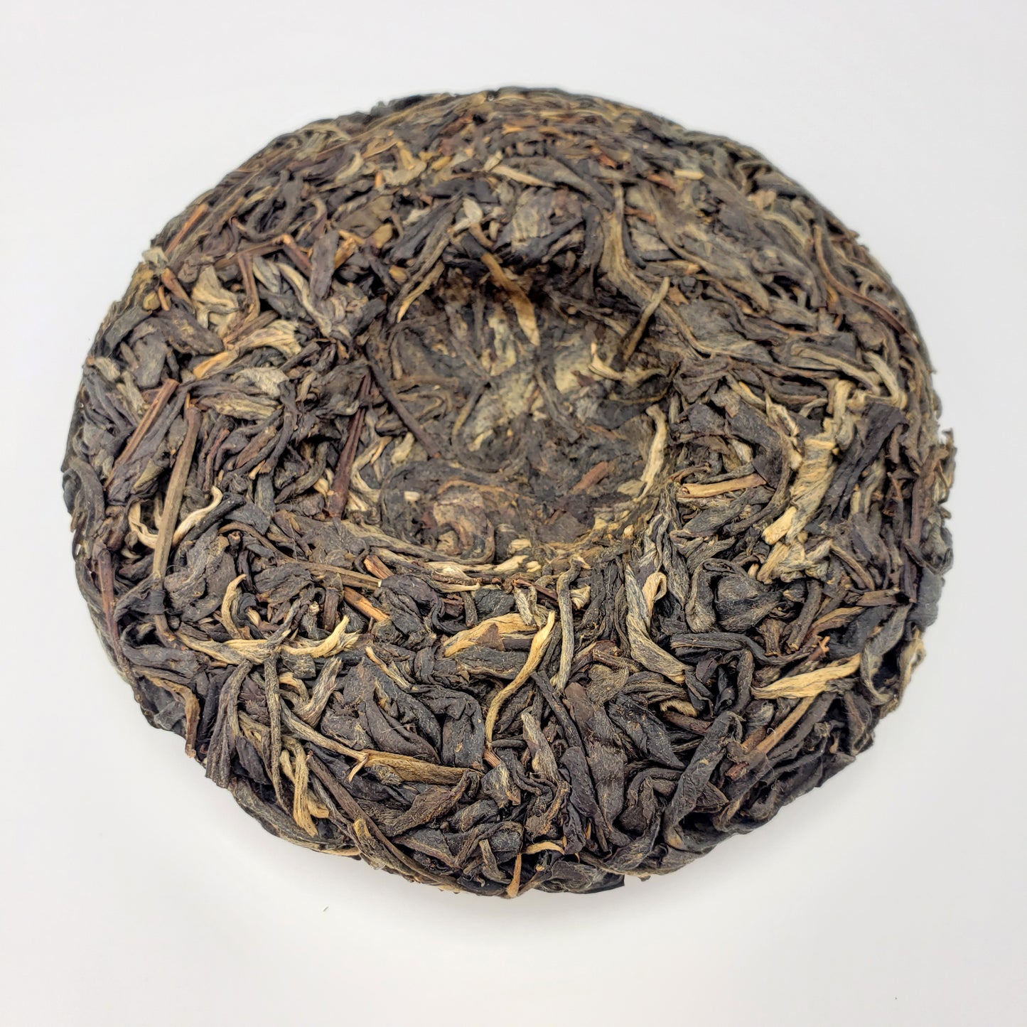 Pressed Pu-erh tea cake on a white background