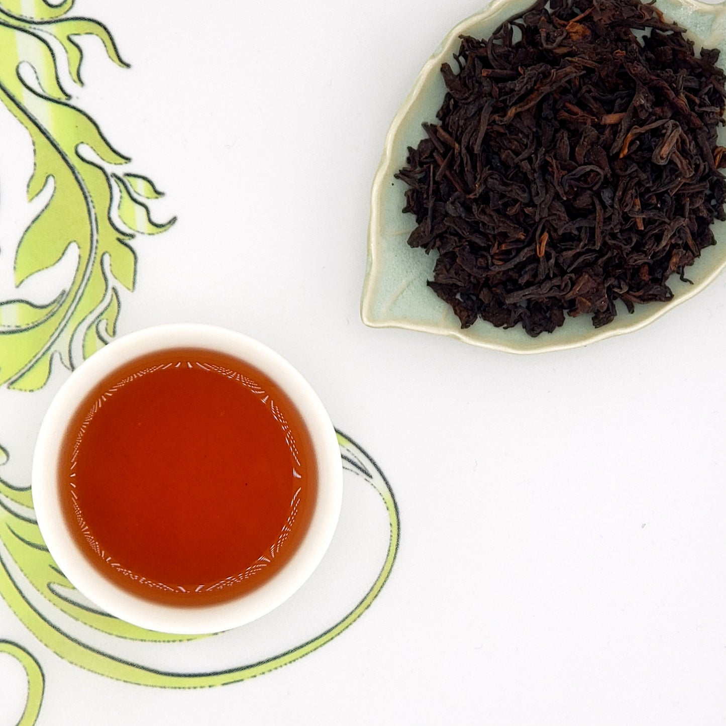 Dry tea leaves and a cup of brewed tea