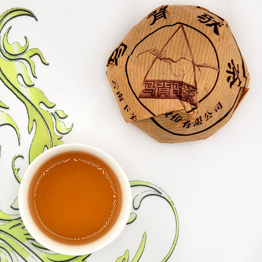 Wrapped tuo cha tea and a cup of brewed tea.