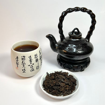 Tea set with a teapot, cup, and bowl of tea leaves on a white background