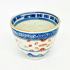 Ceramic cup with blue and red patterns on a white background