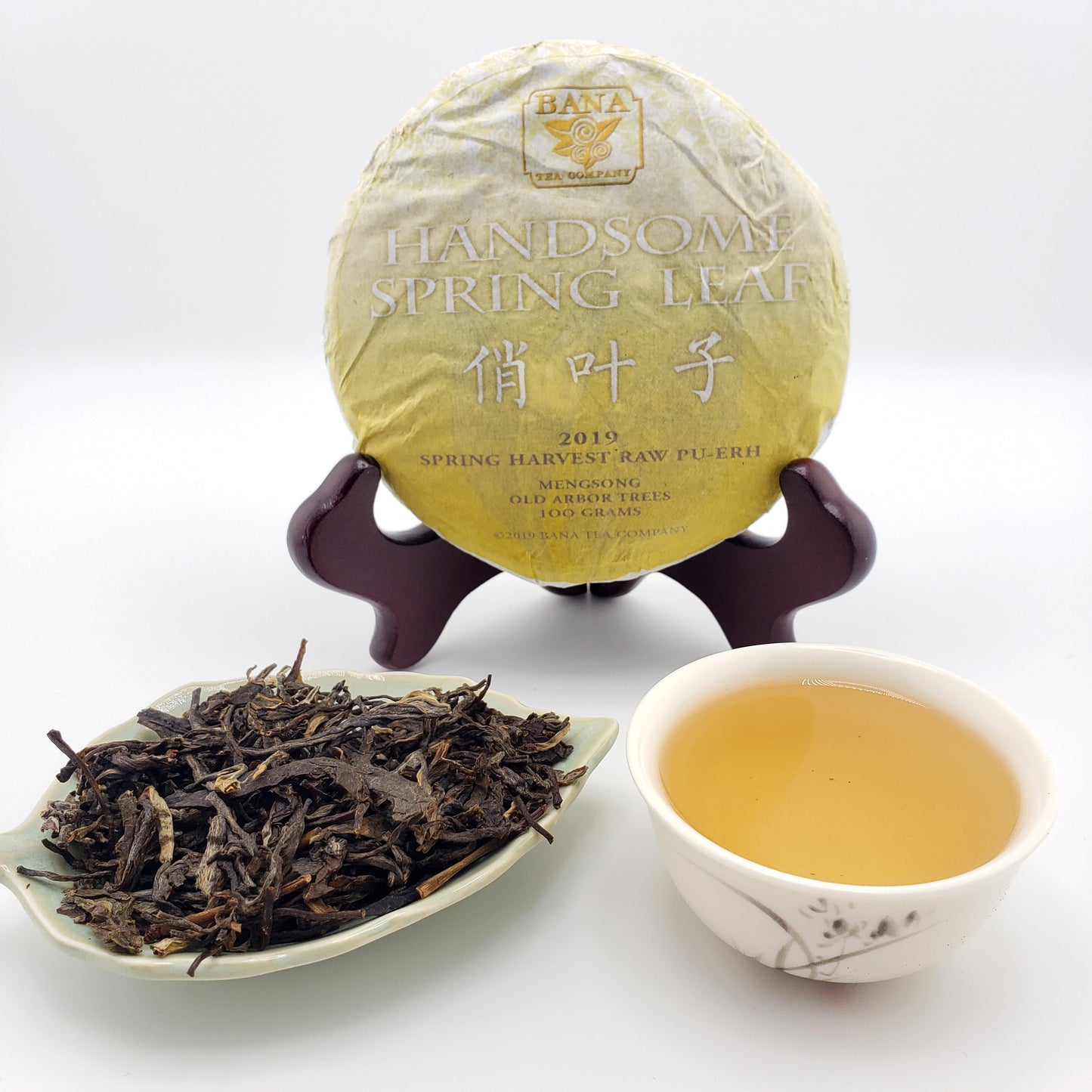 Tea packaging with a cup of tea and loose tea leaves on a white background