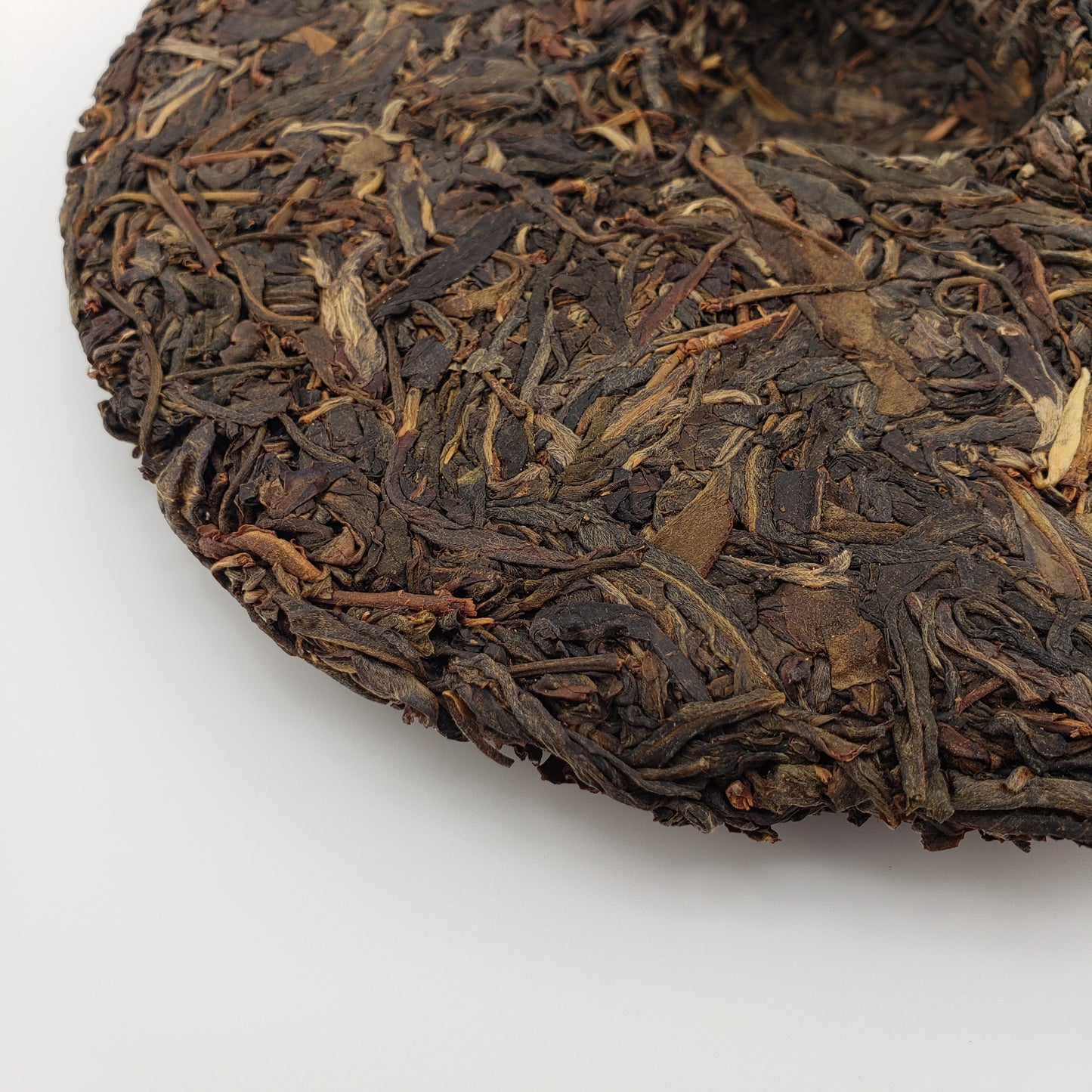 Close-up of pressed pu-erh tea cake on a white background