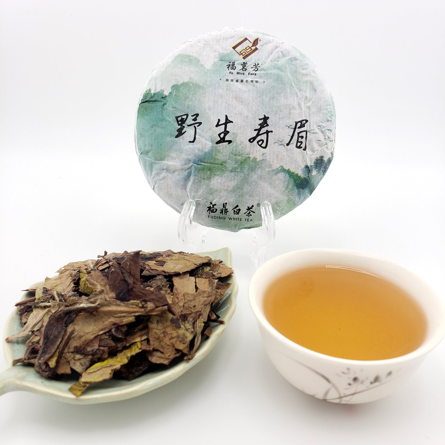Tea cake, brewed tea in a cup, and loose tea leaves on a white background