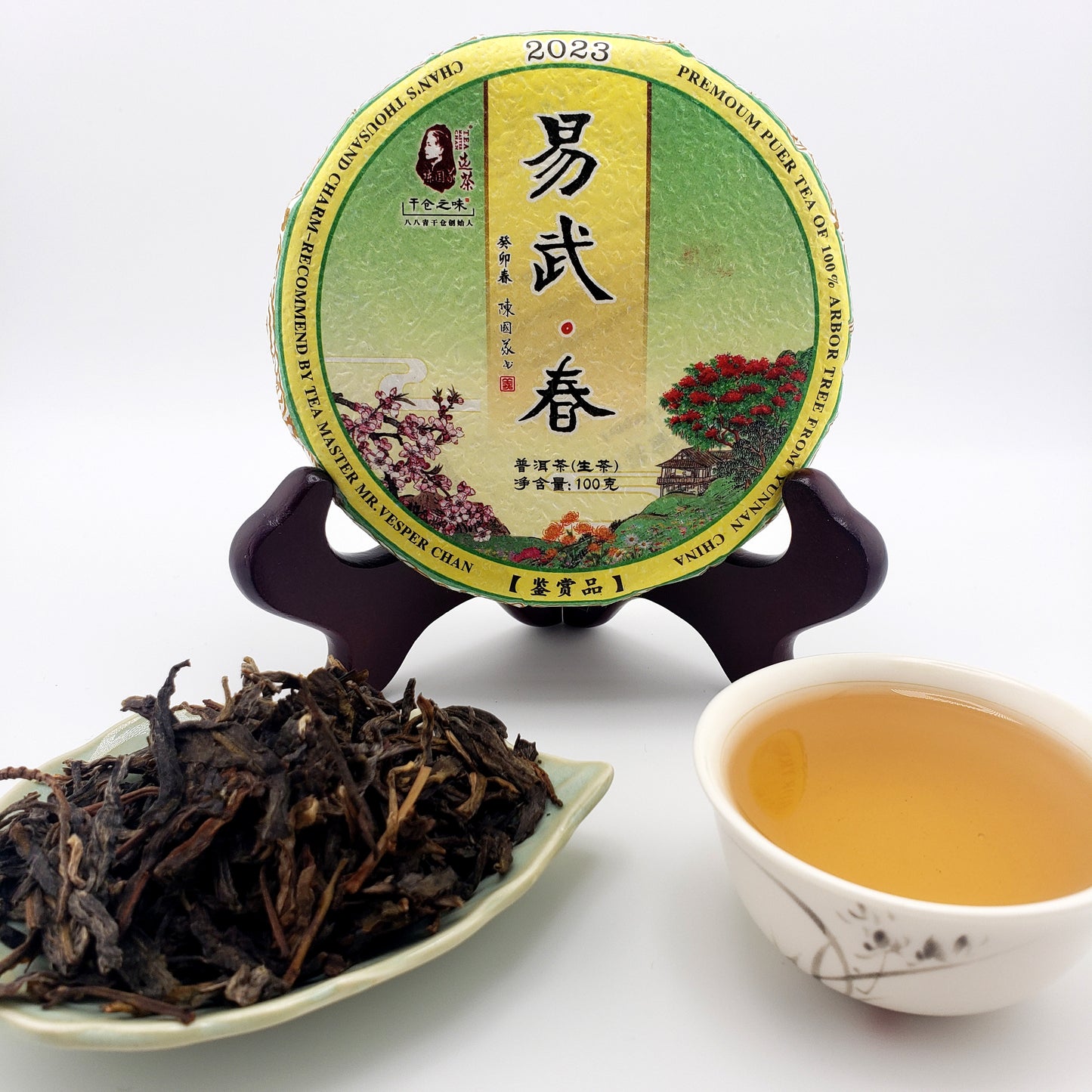 Tea packaging, brewed tea in a cup, and loose tea leaves on a white background